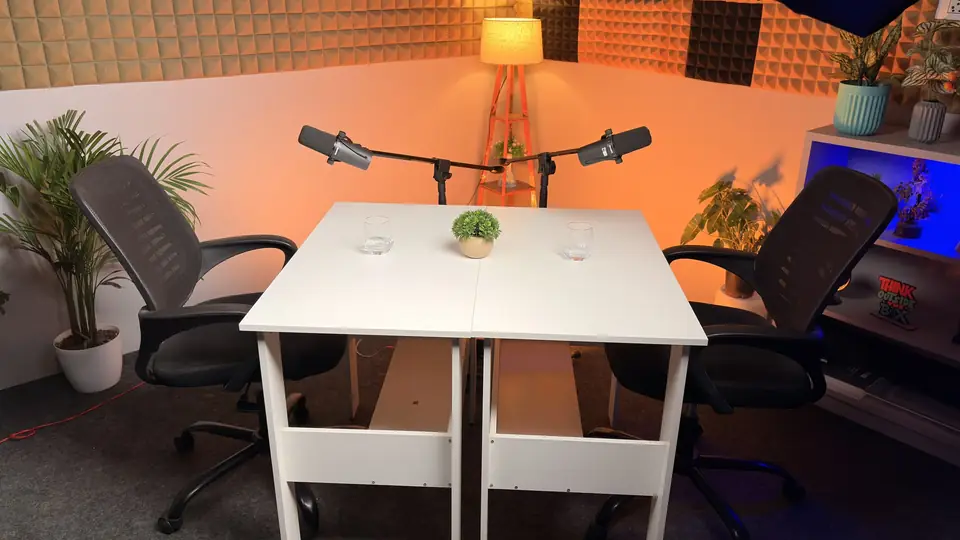 Podcast setup with an acoustic-foam wall, two chairs and two microphones